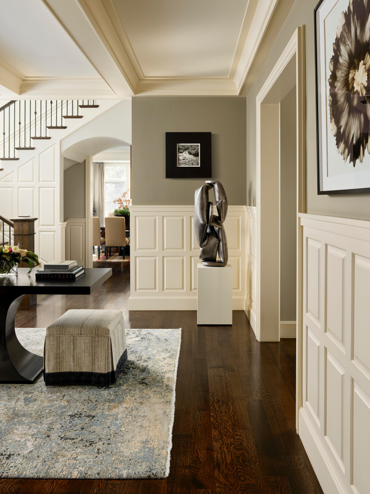 Example of a transitional medium tone wood floor and wainscoting entryway design in Denver