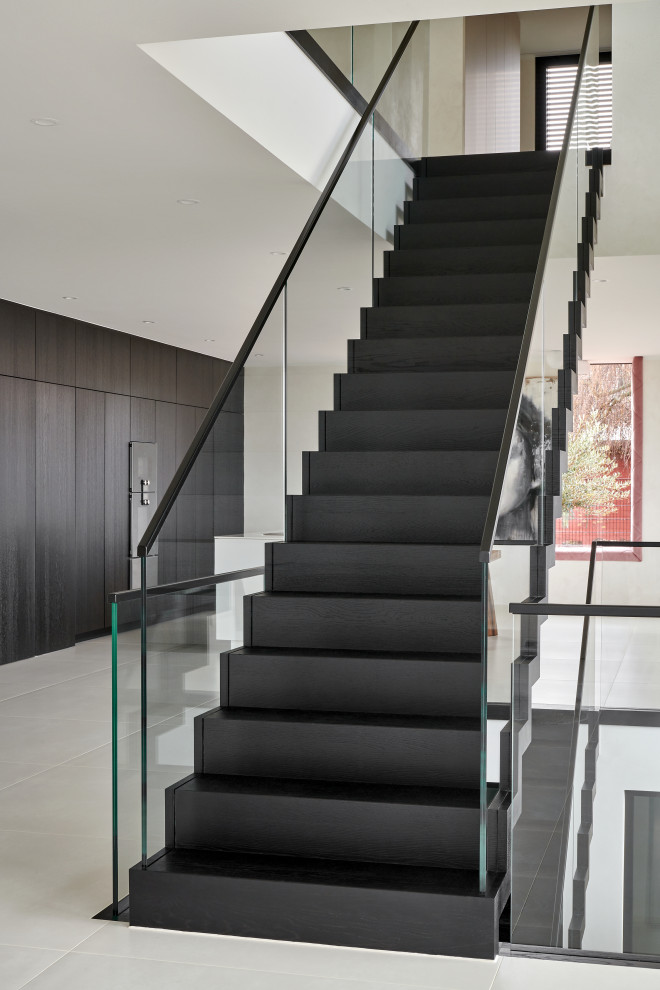Inspiration for a mid-sized contemporary wooden floating glass railing staircase remodel in Stuttgart with wooden risers