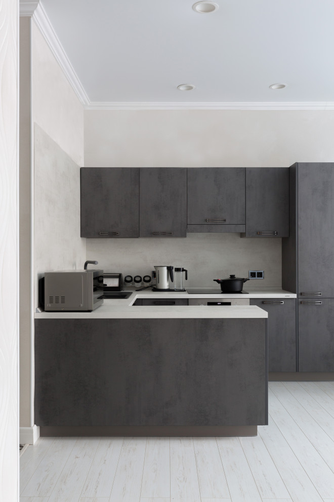 Mid-sized contemporary u-shaped open plan kitchen in Other with an undermount sink, flat-panel cabinets, grey cabinets, solid surface benchtops, grey splashback, black appliances, laminate floors, with island, white floor and white benchtop.