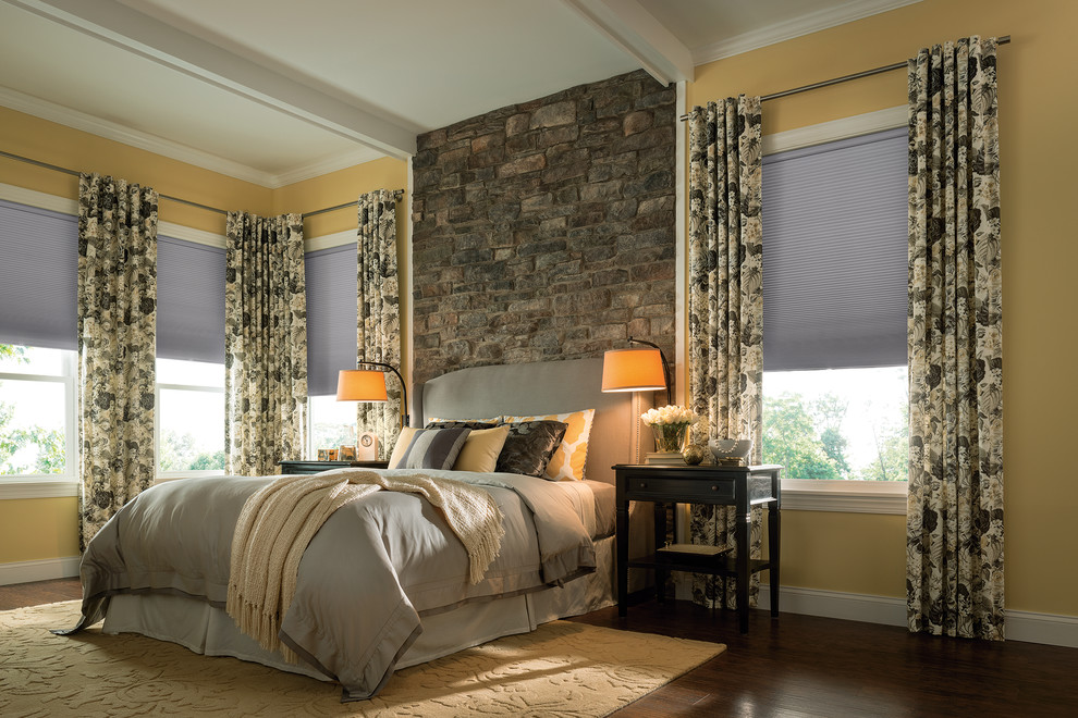 Mid-sized mountain style dark wood floor bedroom photo with yellow walls and no fireplace