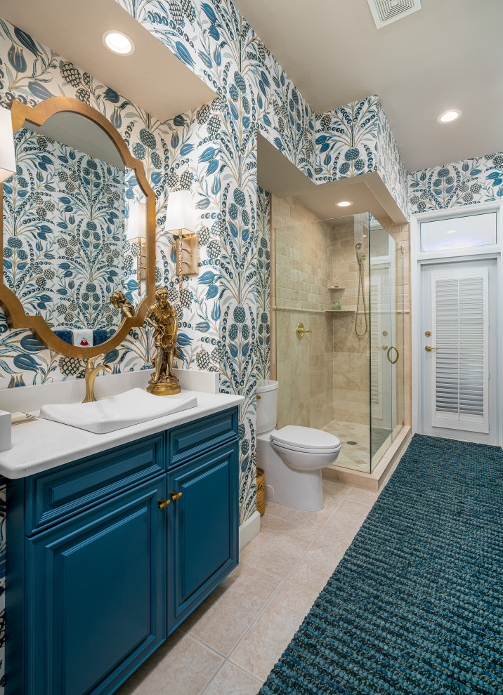This is an example of a transitional master bathroom in Other with raised-panel cabinets, blue cabinets, an alcove shower, a two-piece toilet, multi-coloured walls, a drop-in sink, engineered quartz benchtops, beige floor, a hinged shower door, white benchtops, a single vanity, a built-in vanity and wallpaper.