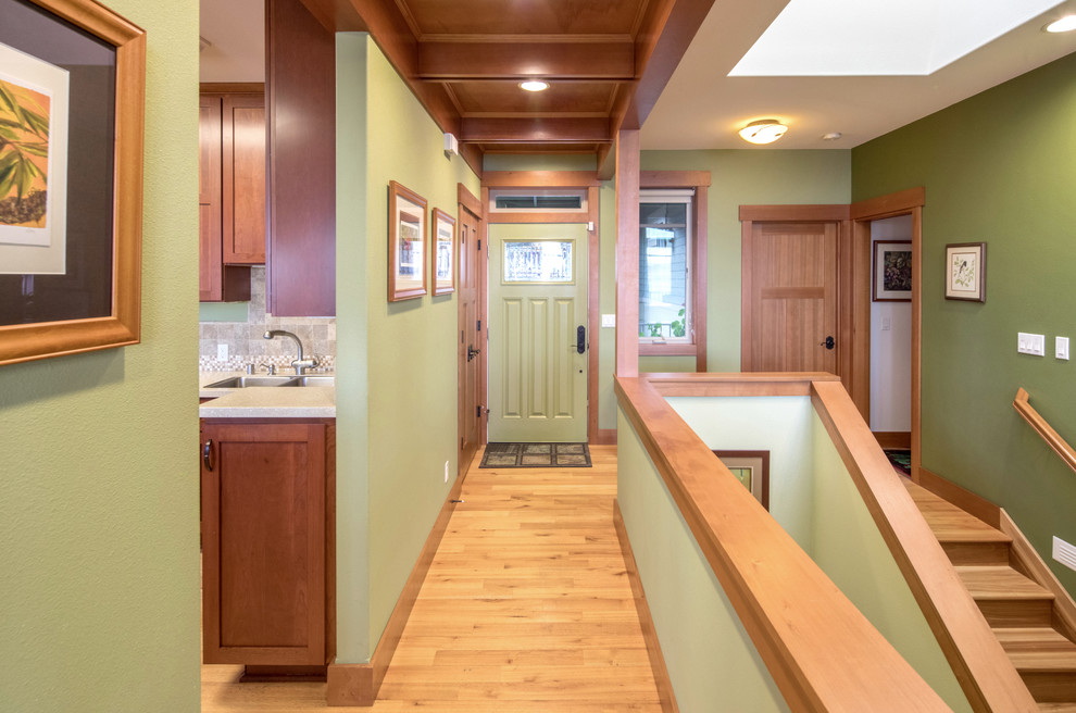 Photo of a mid-sized arts and crafts entry hall in Seattle with green walls, light hardwood floors, a single front door and a green front door.