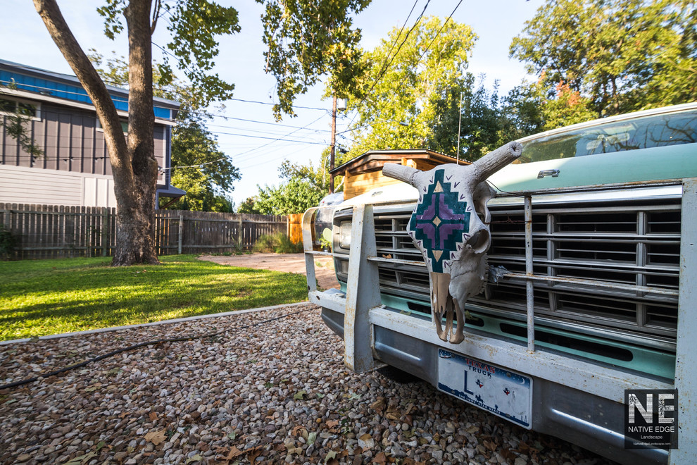 Photo of a mid-sized rustic backyard gravel driveway in Austin.