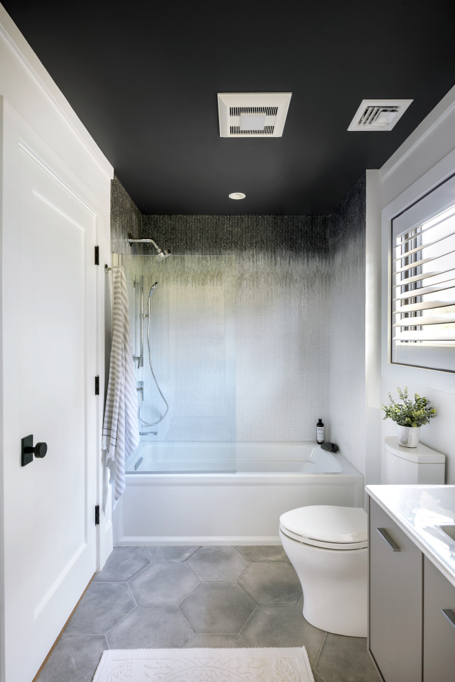 Design ideas for a mid-sized contemporary 3/4 bathroom in New York with flat-panel cabinets, a two-piece toilet, white walls, an integrated sink, quartzite benchtops, white benchtops, a single vanity, a floating vanity, beige cabinets, an alcove tub, a shower/bathtub combo, multi-coloured tile, mosaic tile, porcelain floors and beige floor.