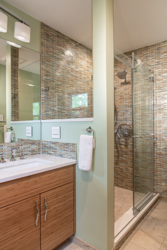 This is an example of a small eclectic master bathroom in St Louis with flat-panel cabinets, beige cabinets, a drop-in tub, an alcove shower, a two-piece toilet, multi-coloured tile, mosaic tile, white walls, marble floors, an undermount sink, engineered quartz benchtops, white floor, a shower curtain and beige benchtops.