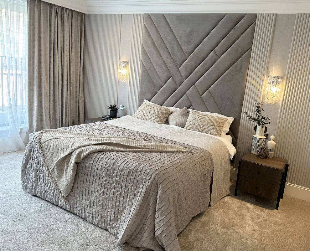 This is an example of a medium sized contemporary master bedroom in London with beige walls, carpet, panelled walls and a feature wall.
