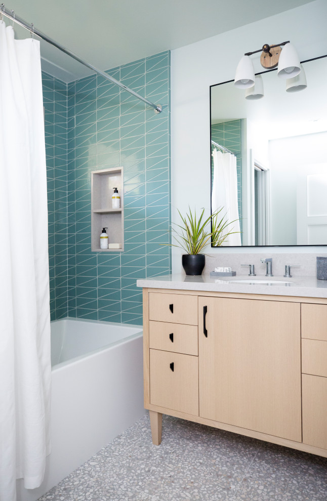 Mid-sized contemporary kids bathroom in San Francisco with flat-panel cabinets, light wood cabinets, an alcove tub, a shower/bathtub combo, blue tile, ceramic tile, white walls, terrazzo floors, an undermount sink, engineered quartz benchtops, grey floor, a shower curtain, beige benchtops, an enclosed toilet, a single vanity and a freestanding vanity.