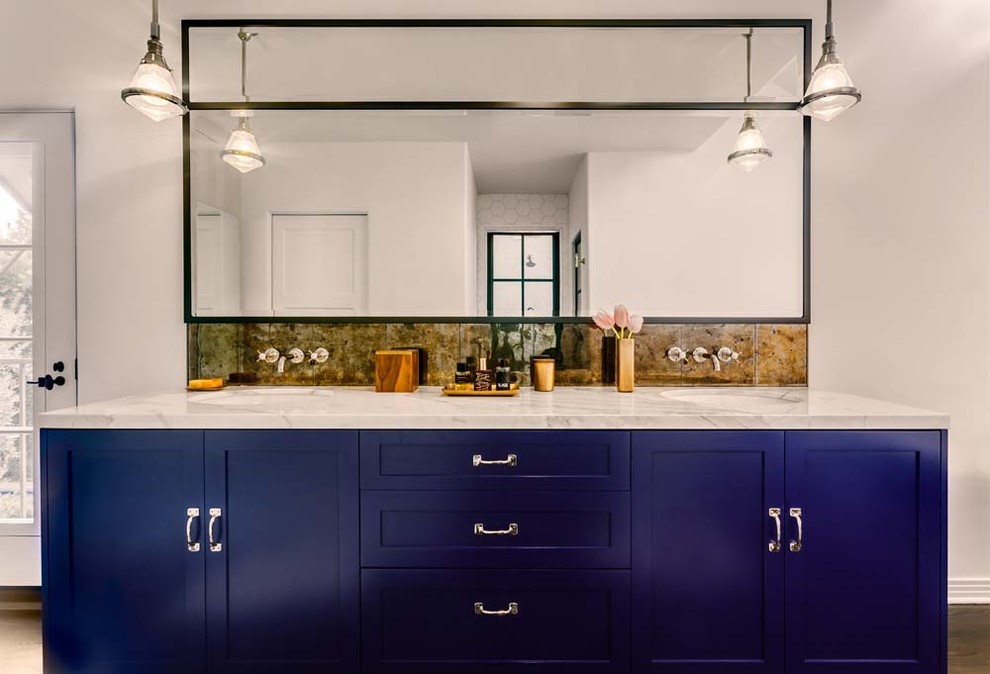 This is an example of a large eclectic master bathroom in Los Angeles with a drop-in sink, shaker cabinets, blue cabinets, marble benchtops, mirror tile, white walls and dark hardwood floors.