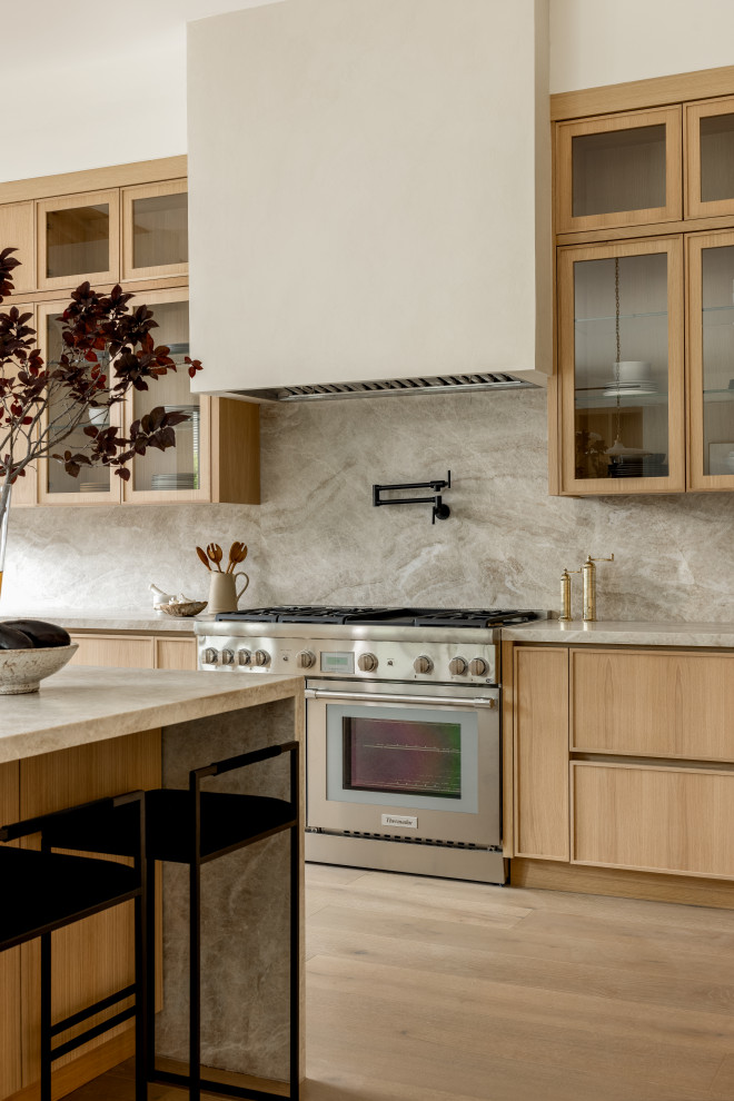 Inspiration for a modern light wood floor and beige floor kitchen remodel in Los Angeles with flat-panel cabinets, beige cabinets, quartzite countertops, beige backsplash, stainless steel appliances and beige countertops