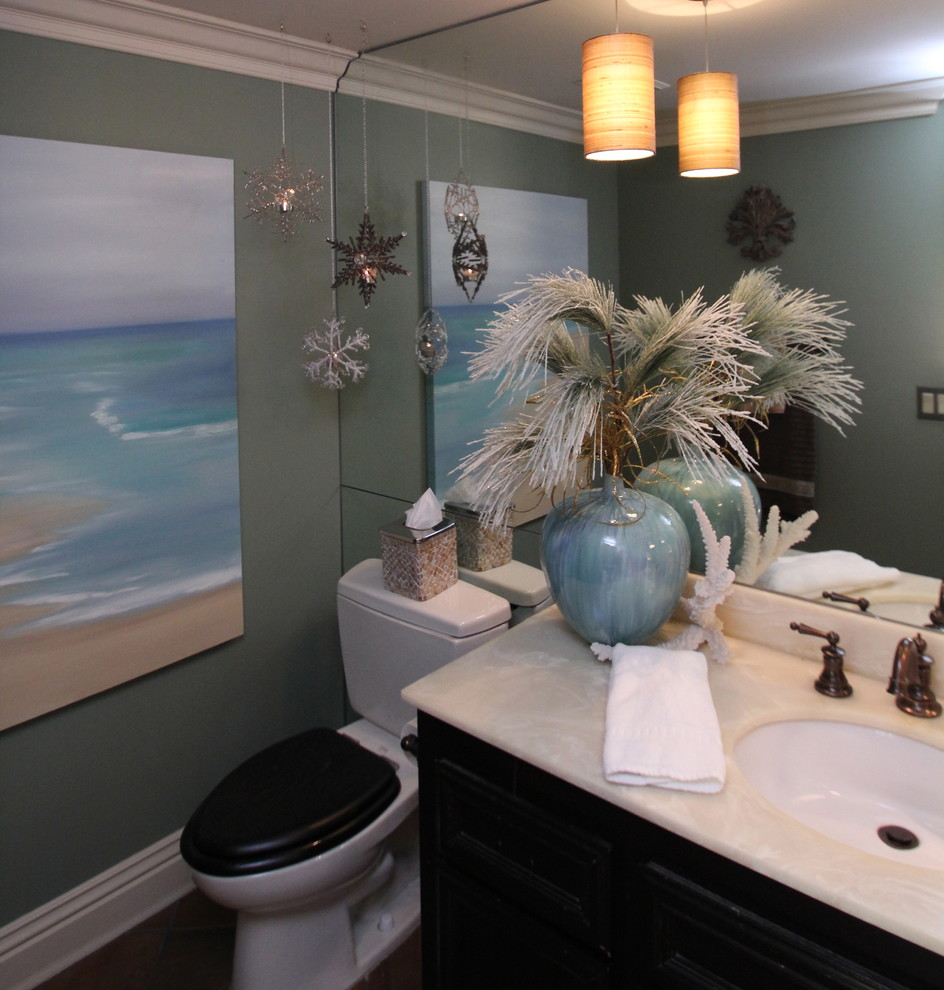 This is an example of a small transitional powder room in San Diego with raised-panel cabinets, dark wood cabinets, a two-piece toilet, green walls, ceramic floors, an undermount sink, engineered quartz benchtops and brown floor.