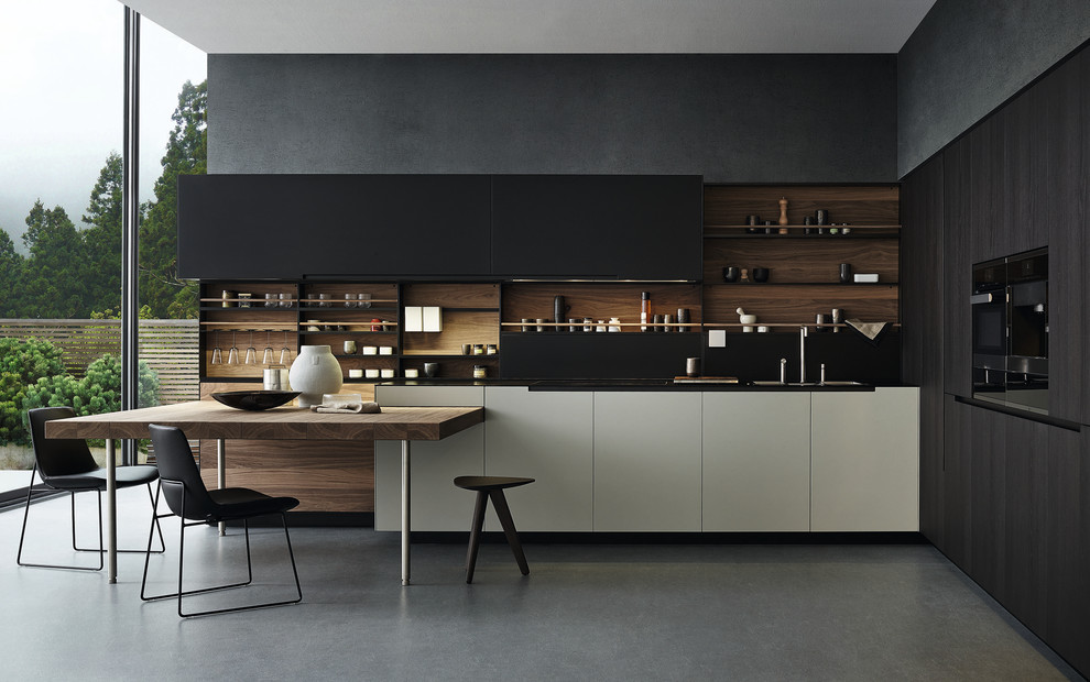 Photo of a contemporary l-shaped kitchen in Sydney with black cabinets, black appliances, flat-panel cabinets, black splashback, concrete floors and black benchtop.