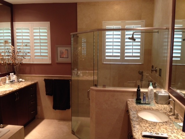 Example of a mid-sized trendy master beige tile and stone tile marble floor bathroom design in Other with an undermount sink, flat-panel cabinets, medium tone wood cabinets, granite countertops, a one-piece toilet and brown walls