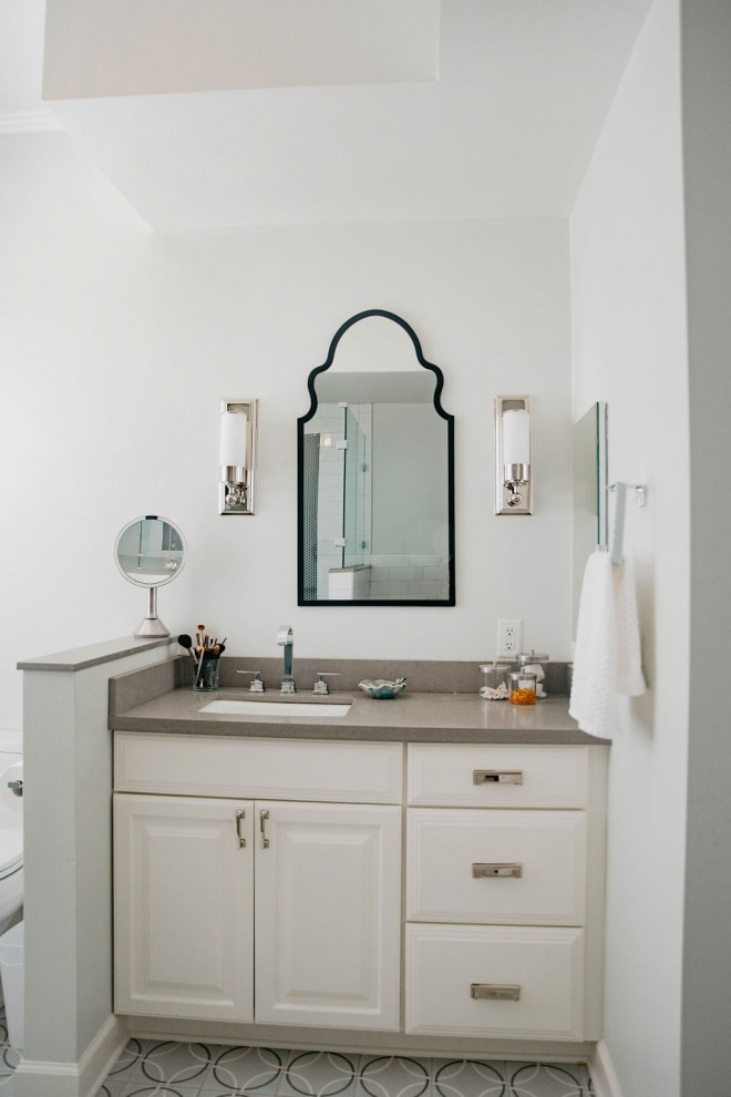 Design ideas for a mid-sized contemporary master bathroom in Little Rock with raised-panel cabinets, white cabinets, an alcove tub, a corner shower, a one-piece toilet, white tile, ceramic tile, blue walls, cement tiles, an undermount sink, engineered quartz benchtops, grey floor, a hinged shower door, grey benchtops, a niche, a single vanity, a built-in vanity and recessed.