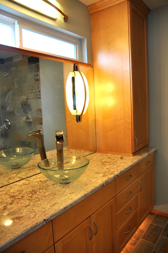 Inspiration for a small transitional stone tile slate floor corner shower remodel in Seattle with a vessel sink, recessed-panel cabinets, light wood cabinets, granite countertops and blue walls