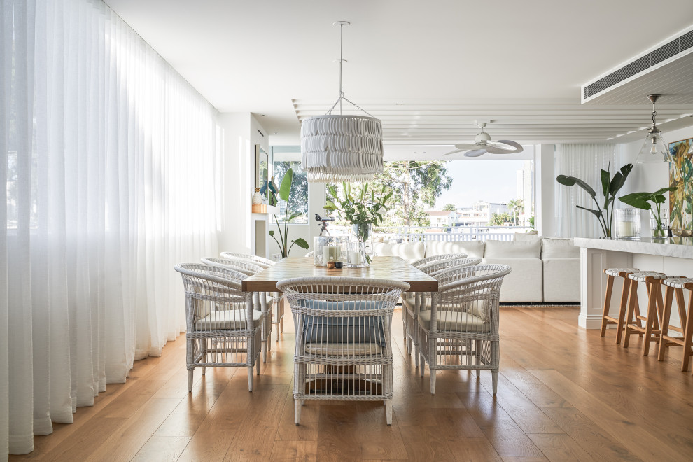 Inspiration for a beach style dining room in Gold Coast - Tweed with white walls, medium hardwood floors and brown floor.