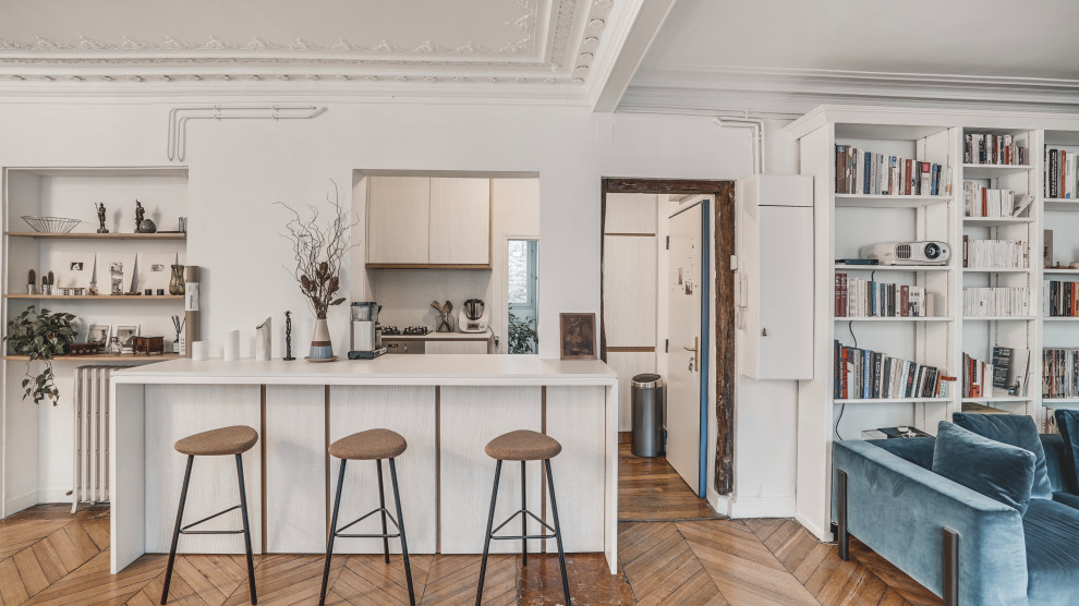 Photo of a mid-sized scandinavian open plan kitchen in Paris with white cabinets, medium hardwood floors, no island, brown floor and white benchtop.