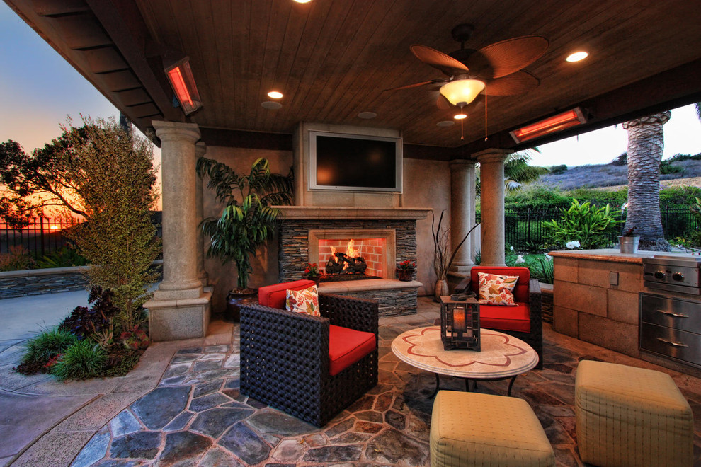 Inspiration for a traditional patio in Orange County with natural stone pavers and a roof extension.