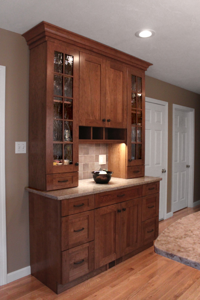 Inspiration for a large transitional u-shaped light wood floor eat-in kitchen remodel in Boston with an undermount sink, shaker cabinets, medium tone wood cabinets, quartz countertops, gray backsplash, porcelain backsplash, stainless steel appliances and a peninsula