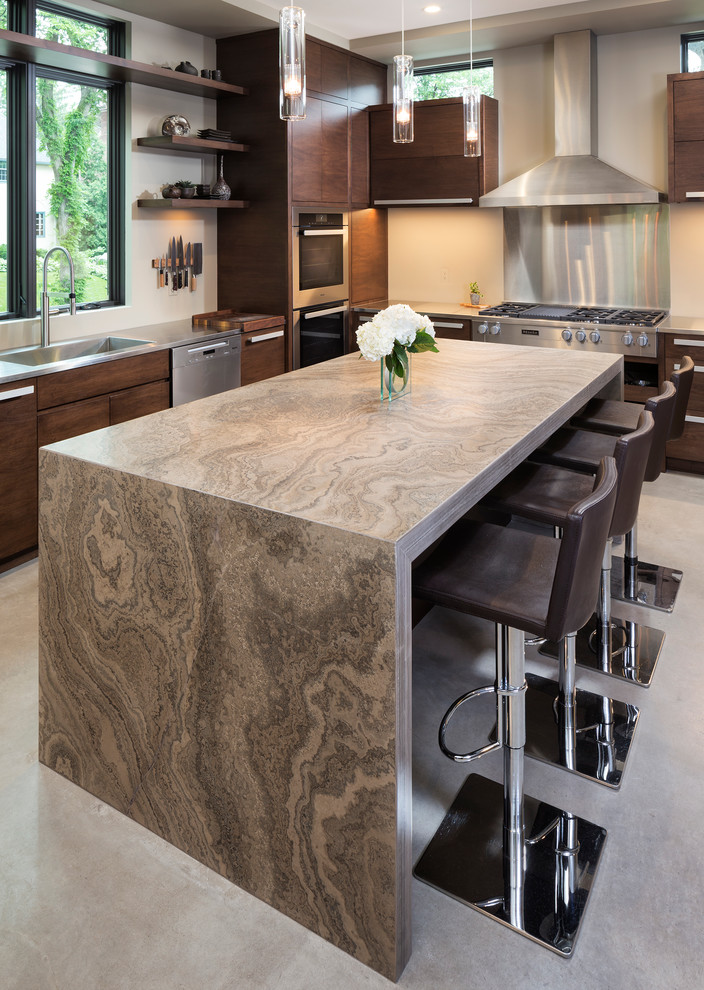 Photo of a small modern kitchen in Minneapolis with flat-panel cabinets, medium wood cabinets, limestone benchtops, beige splashback, stainless steel appliances, concrete floors and with island.