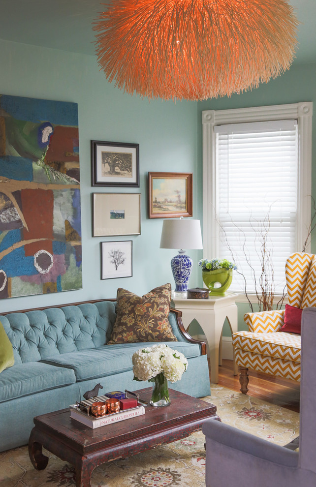 This is an example of a mid-sized eclectic formal open concept living room in Boston with blue walls, medium hardwood floors, no fireplace and no tv.