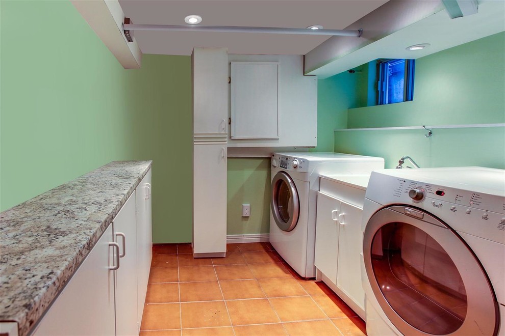 Design ideas for a mid-sized contemporary dedicated laundry room in Toronto with a drop-in sink, flat-panel cabinets, white cabinets, laminate benchtops, green walls, ceramic floors and a side-by-side washer and dryer.