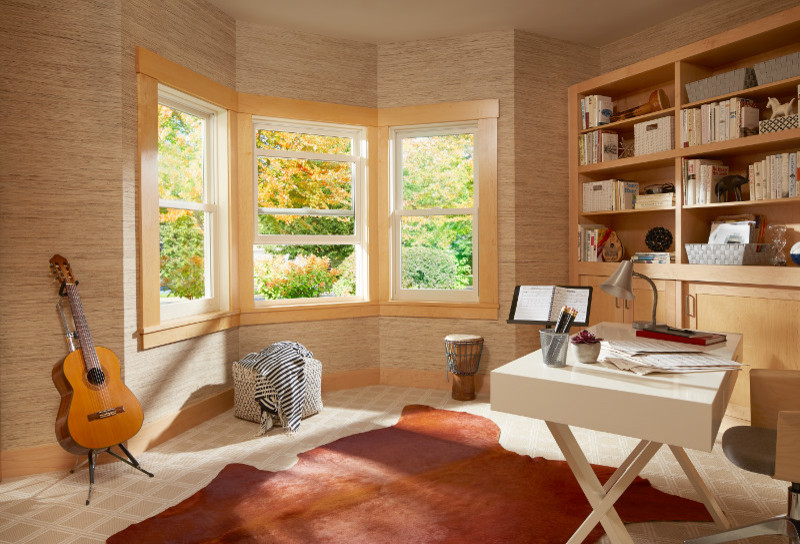 This is an example of a large modern study room in Other with beige walls, carpet, no fireplace, a freestanding desk and beige floor.