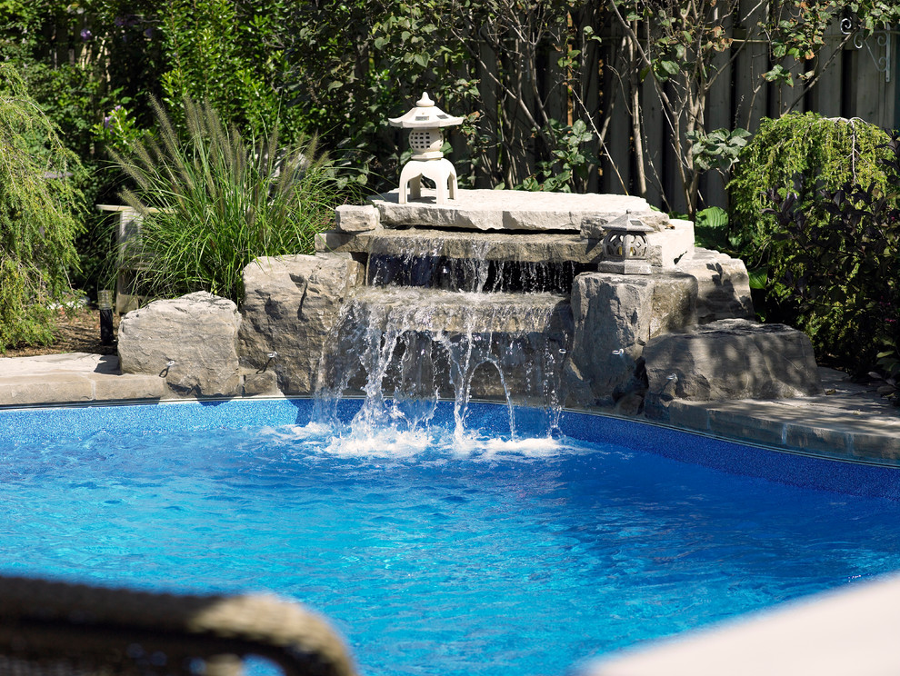 Design ideas for a large contemporary backyard custom-shaped natural pool in Toronto with a water feature and concrete pavers.