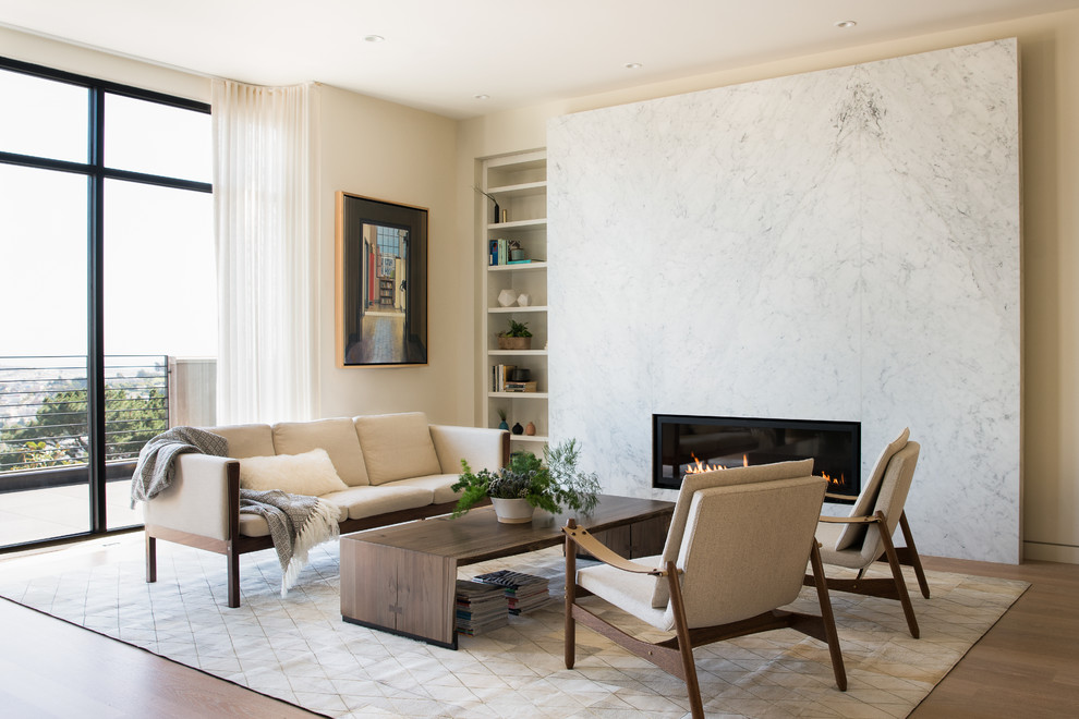 Photo of a mid-sized contemporary formal open concept living room in San Francisco with beige walls, light hardwood floors, a ribbon fireplace, a stone fireplace surround and no tv.