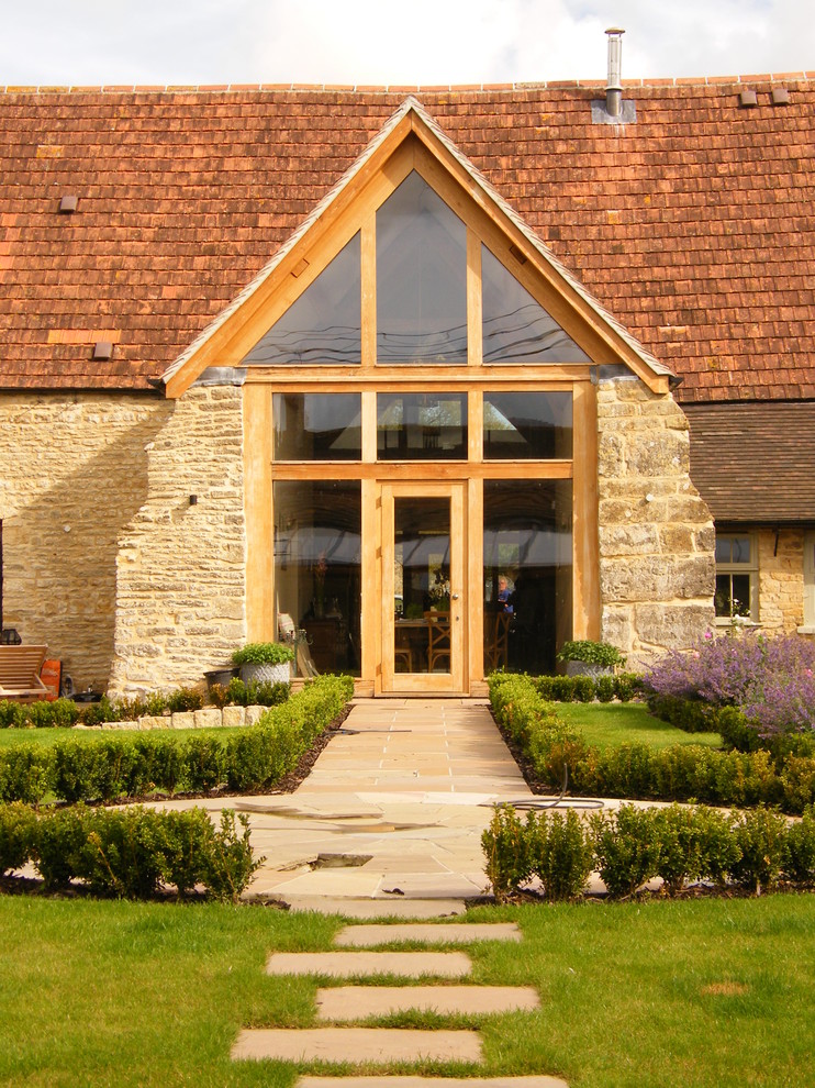Photo of a country exterior in Dorset with stone veneer and a gable roof.