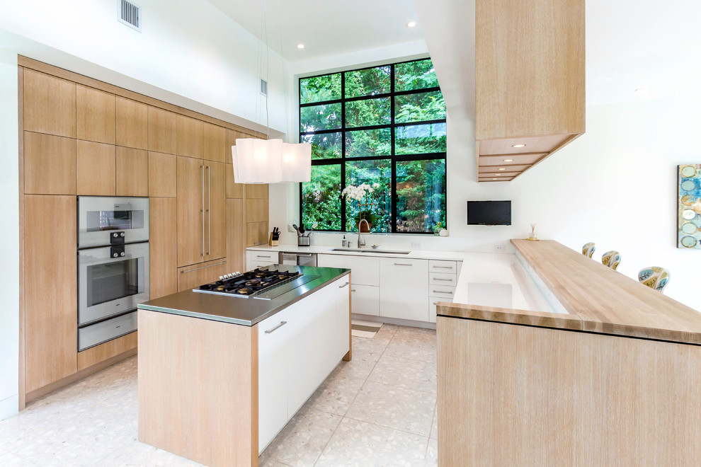 Photo of a mid-sized contemporary u-shaped eat-in kitchen in New York with flat-panel cabinets, light wood cabinets and with island.