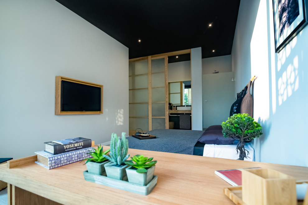 Photo of a mid-sized asian loft-style bedroom with grey walls and ceramic floors.