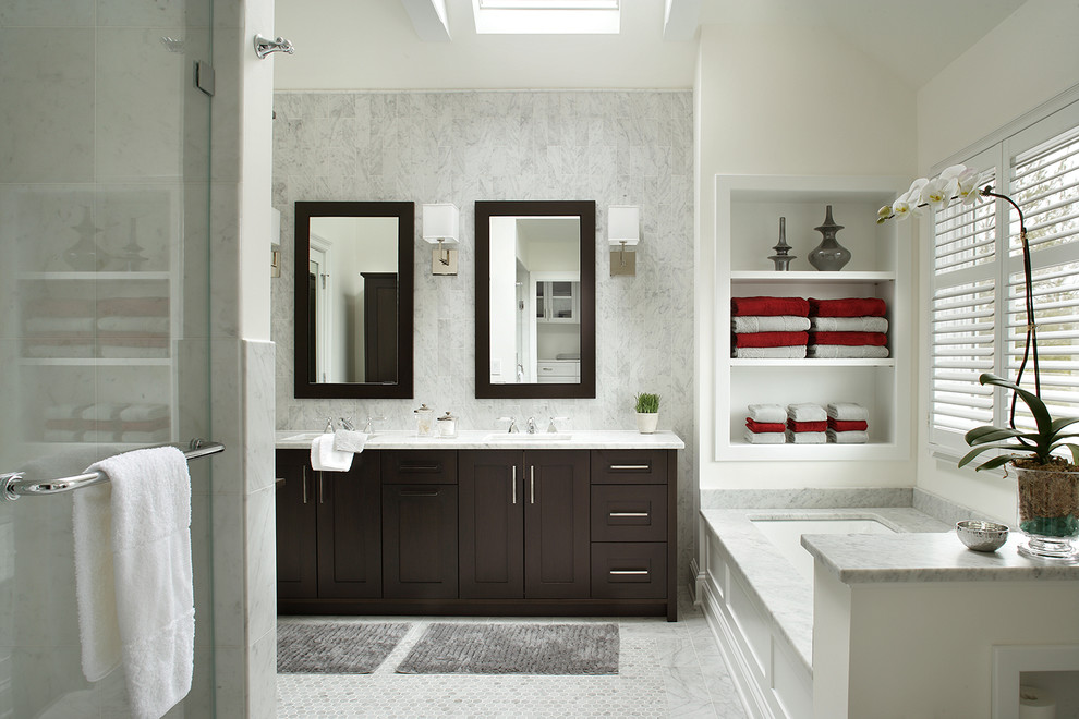 Transitional master bathroom in New York with an undermount sink, shaker cabinets, dark wood cabinets, an undermount tub, white tile, white walls and stone tile.
