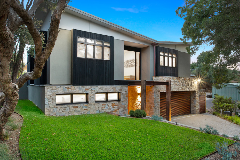 Large contemporary two-storey grey house exterior in Melbourne with mixed siding, a gable roof and a metal roof.