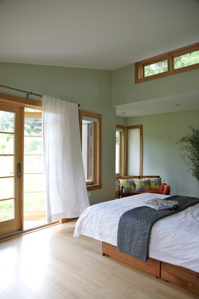 Contemporary bedroom in DC Metro with green walls and light hardwood floors.