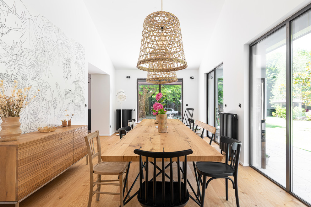 Inspiration for a contemporary open plan dining in Lyon with white walls, light hardwood floors, beige floor and vaulted.