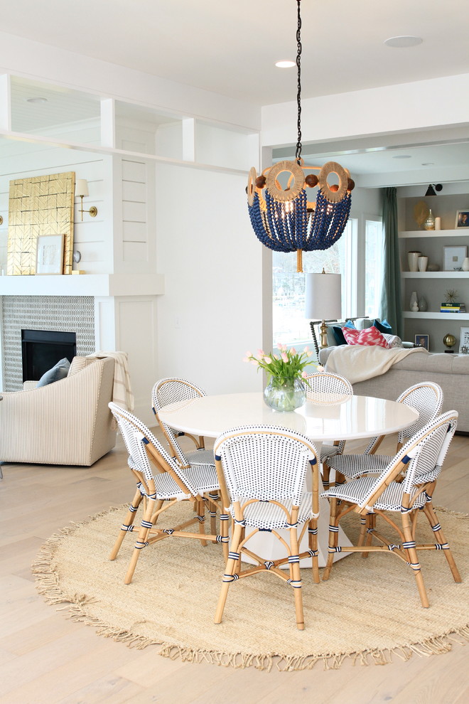 Design ideas for a beach style open plan dining in Grand Rapids with white walls and light hardwood floors.