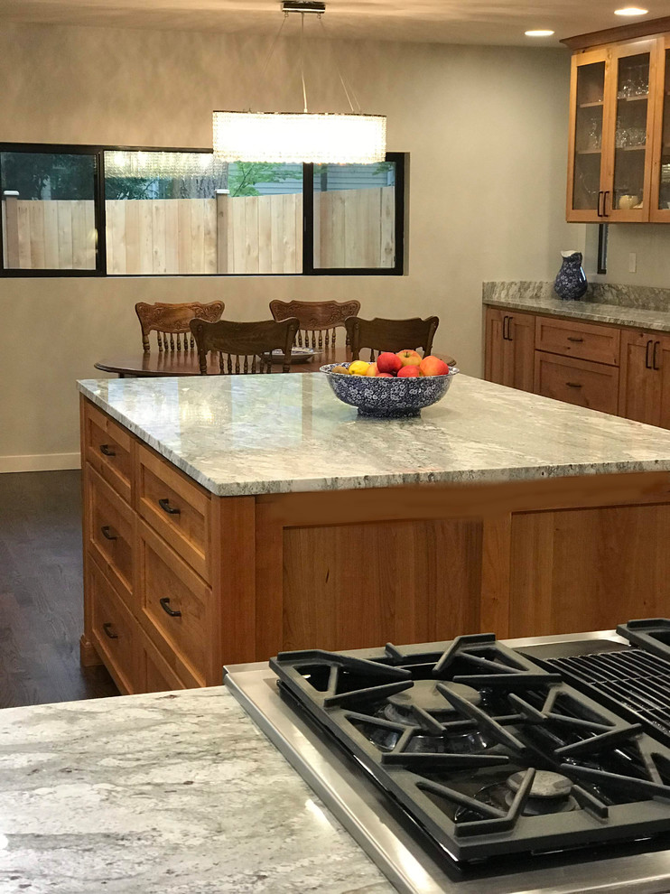 Mid-sized transitional l-shaped dark wood floor and brown floor eat-in kitchen photo in Seattle with a farmhouse sink, shaker cabinets, medium tone wood cabinets, granite countertops, stainless steel appliances, an island and gray countertops