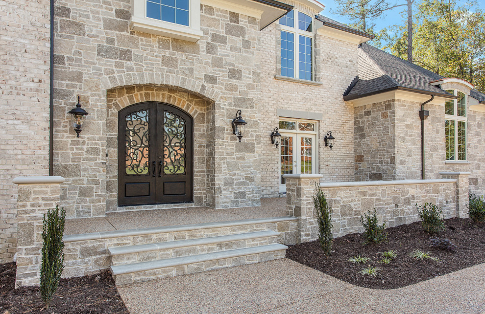 Photo of a two-storey white house exterior in Richmond with stone veneer, a hip roof and a shingle roof.