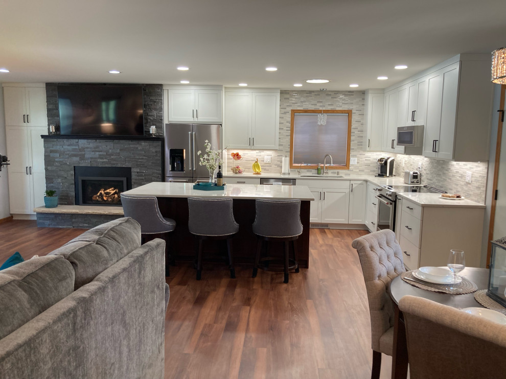 Mid-sized transitional l-shaped eat-in kitchen in Other with shaker cabinets, white cabinets, quartz benchtops, with island and white benchtop.