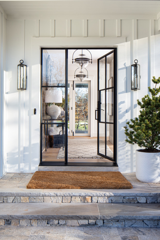 Immagine di una porta d'ingresso country di medie dimensioni con pareti bianche, pavimento in legno massello medio, una porta singola, una porta in vetro e pavimento beige