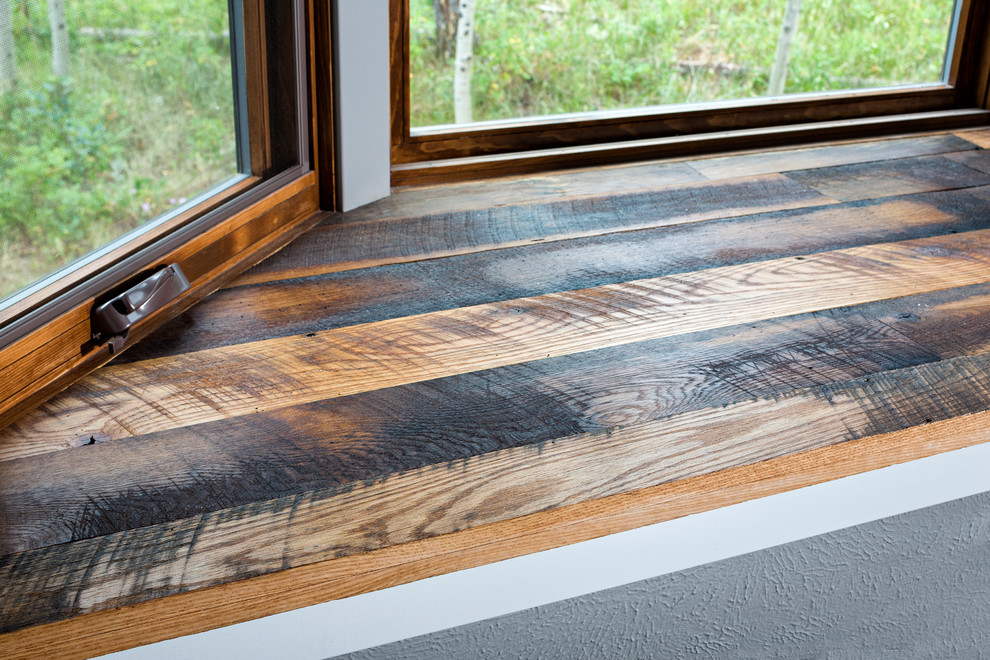 Mountain style medium tone wood floor and brown floor dining room photo in Denver with gray walls
