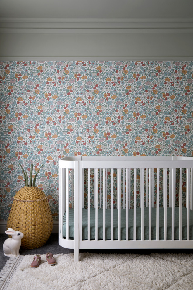 Small modern nursery in London with green walls, carpet, grey floor and wallpaper for girls.