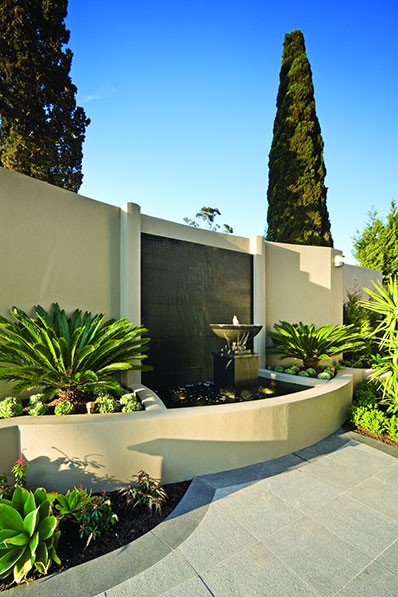 Mid-sized mediterranean backyard garden in Orange County with a water feature and natural stone pavers.