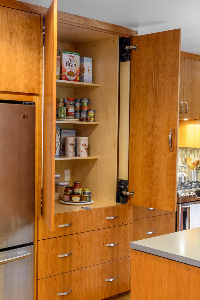 Photo of a large arts and crafts l-shaped kitchen pantry in Los Angeles with a double-bowl sink, flat-panel cabinets, medium wood cabinets, quartz benchtops, beige splashback, mosaic tile splashback, stainless steel appliances, medium hardwood floors and with island.