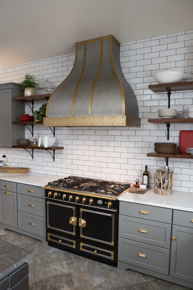 Eat-in kitchen - large transitional u-shaped porcelain tile and gray floor eat-in kitchen idea in Chicago with a farmhouse sink, shaker cabinets, gray cabinets, limestone countertops, white backsplash, subway tile backsplash, black appliances and an island