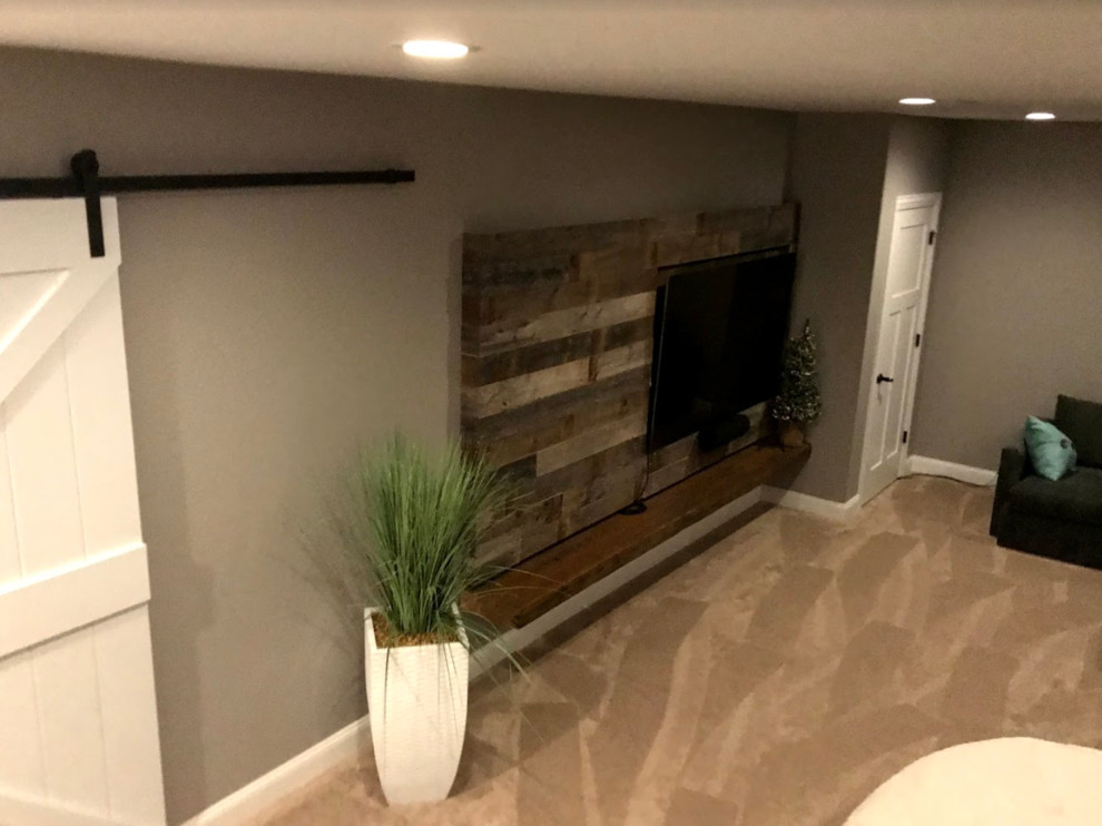Design ideas for a large transitional fully buried basement in Other with beige walls, carpet, a standard fireplace, a metal fireplace surround and beige floor.