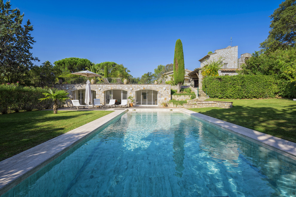Design ideas for a large mediterranean backyard rectangular lap pool in Nice with decking.
