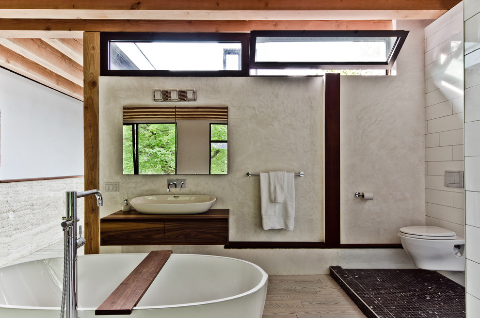 Photo of a contemporary bathroom in Montreal with a vessel sink, a freestanding tub and subway tile.