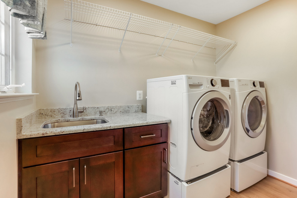 Design ideas for a small transitional galley dedicated laundry room in DC Metro with an undermount sink, shaker cabinets, medium wood cabinets, granite benchtops, a side-by-side washer and dryer and multi-coloured benchtop.