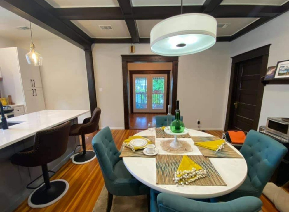 Esempio di una sala da pranzo aperta verso la cucina minimalista di medie dimensioni con pavimento in legno massello medio e soffitto a cassettoni